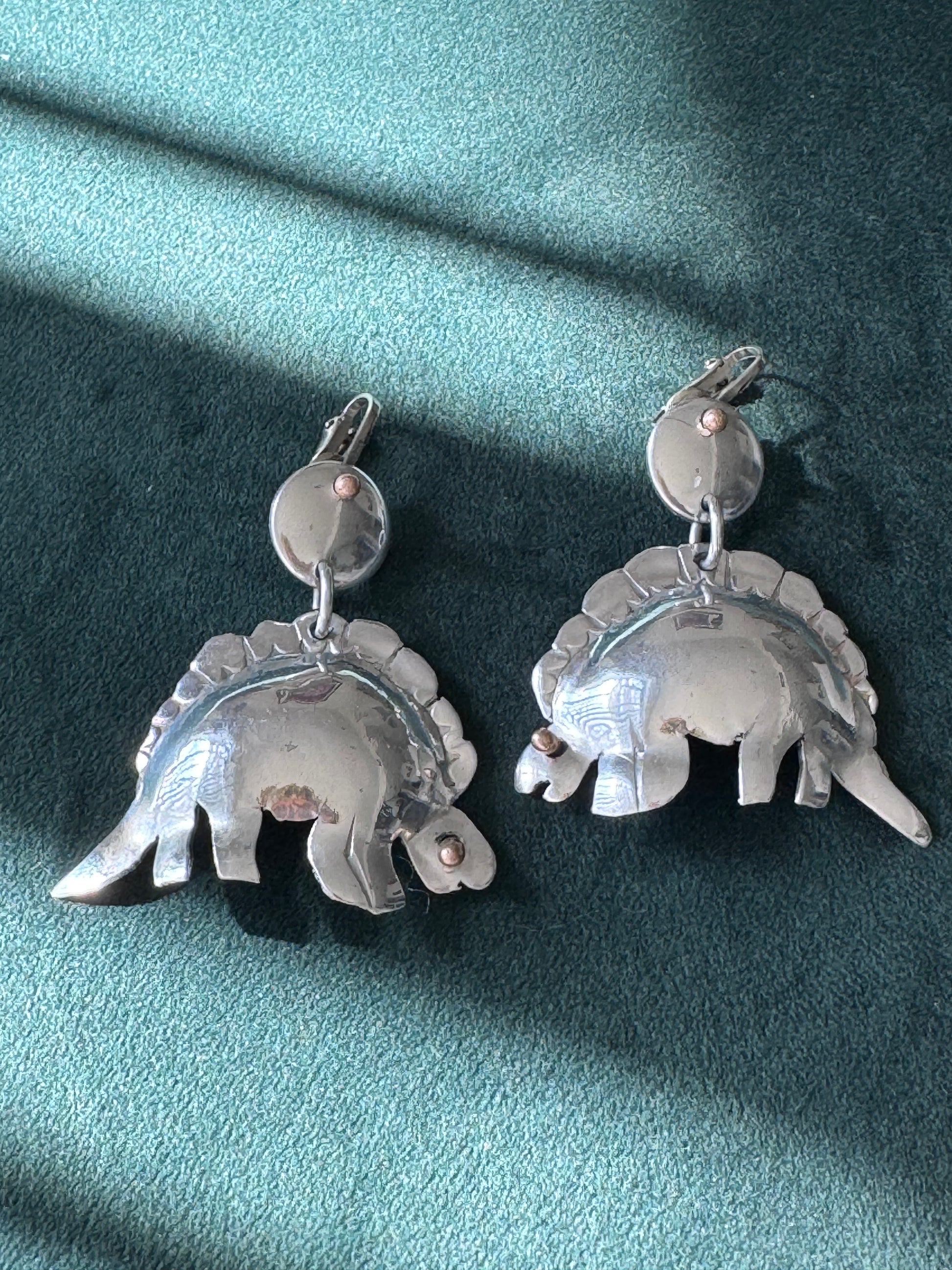 Large vintage silver stegosaurus dinosaur statement dangle clip-on earrings with gold-tone accents, handmade oversized hollow-form construction