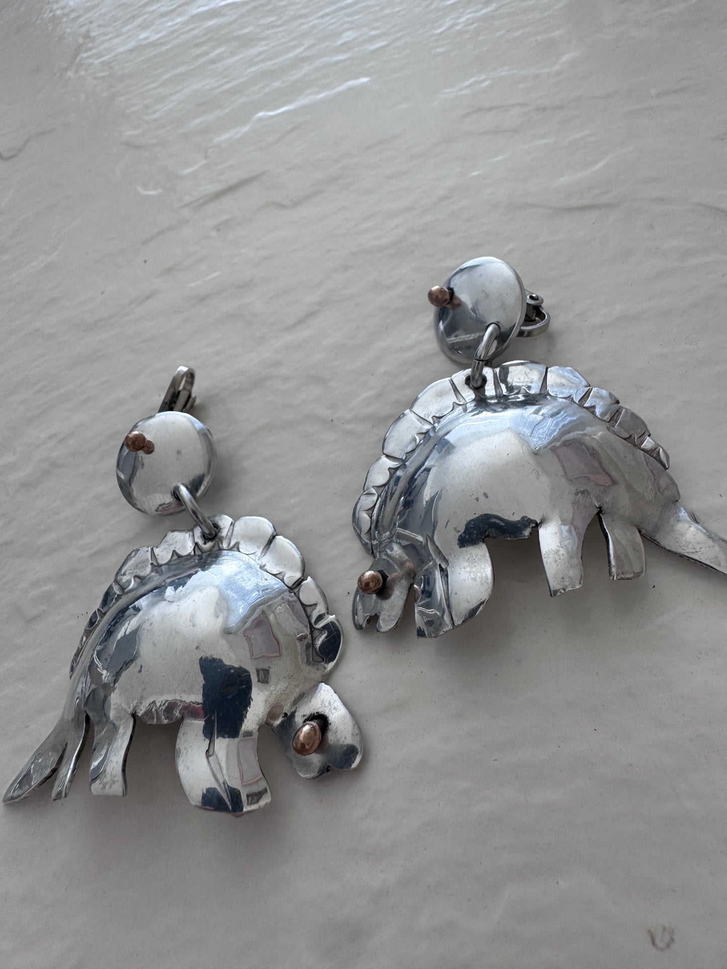 Large vintage silver stegosaurus dinosaur statement dangle clip-on earrings with gold-tone accents, handmade oversized hollow-form construction