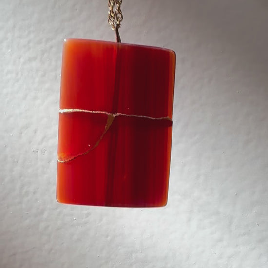 Estate 14K gold pendant featuring natural red carnelian rectangle with dramatic gold strike mineral inclusions embodying wabi sabi aesthetics