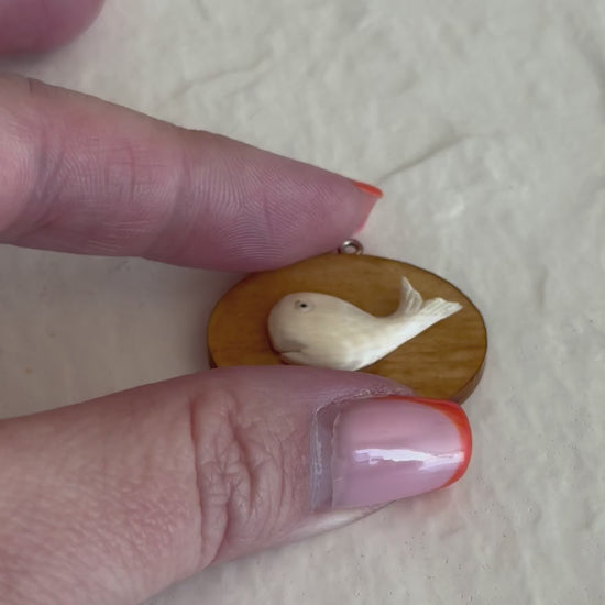 Vintage scrimshaw-style carved whale pendant on natural wood oval with sterling silver bail