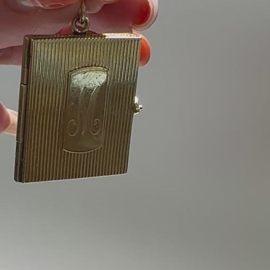 Vintage 14K gold book locket with hinged pages, engine-turned texture, engraved details, multiple photo compartments