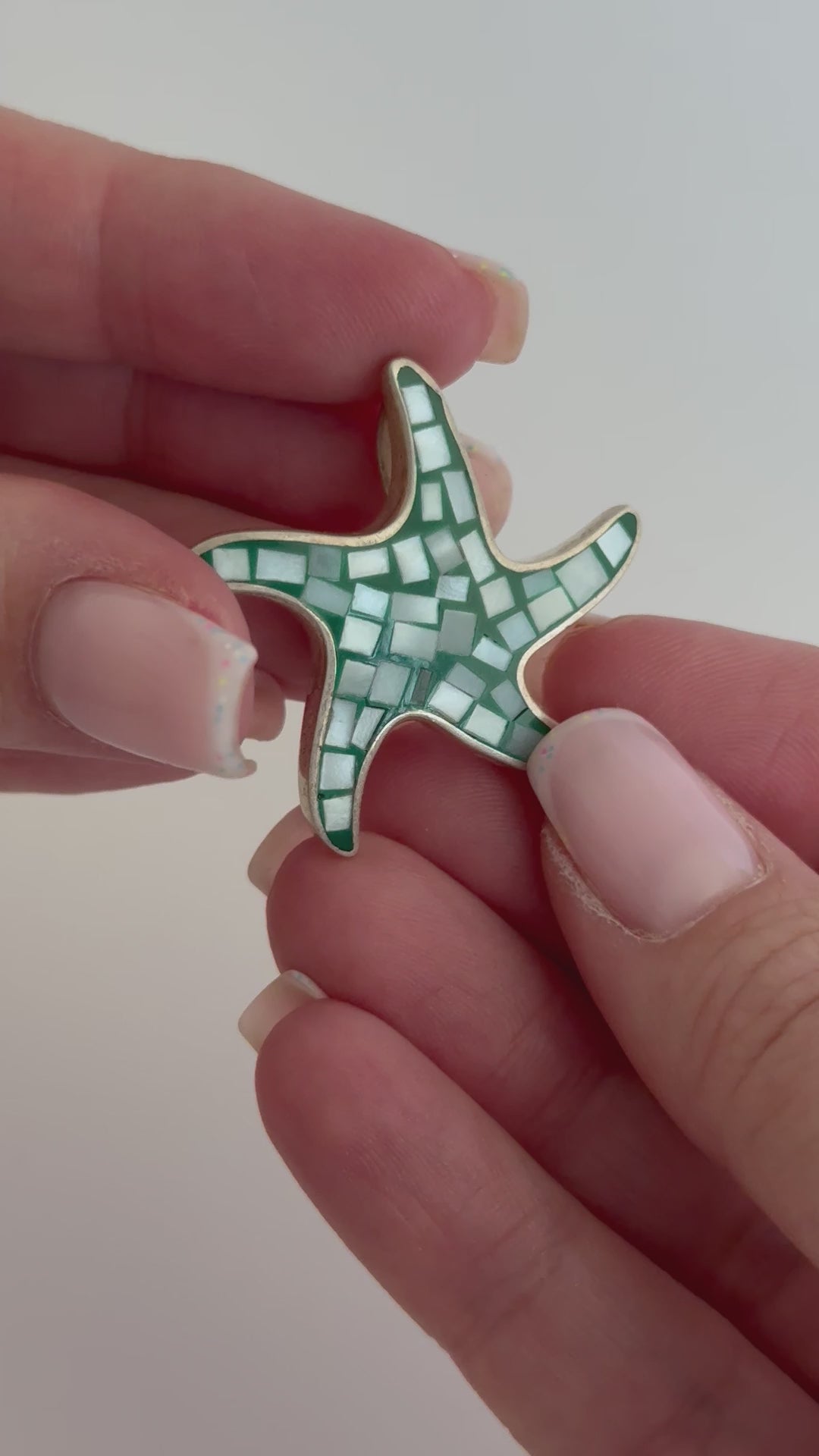 Vintage sterling silver starfish pendant with mother of pearl and green resin mosaic inlay, showing detailed craftsmanship and 925 hallmark