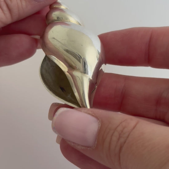 Large vintage sterling silver conch shell pendant with AI signature, showing detailed spiral shell design and high-polish finish