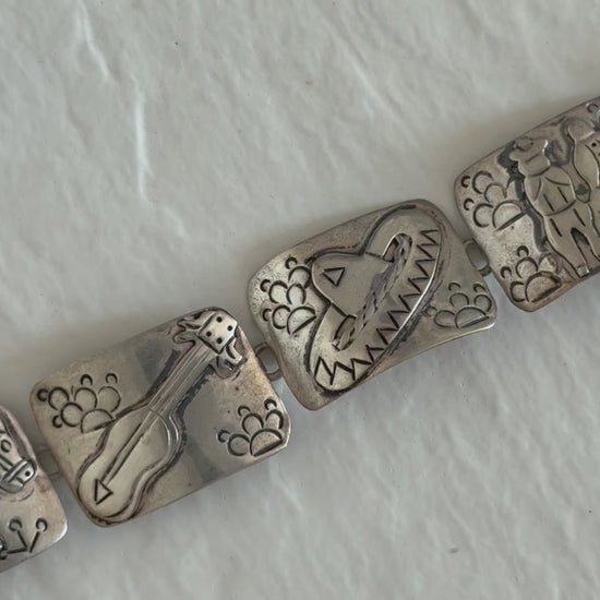 Estate J. Alvarez Taxco Mexican sterling silver storyteller panel bracelet showing detailed cultural scenes with guitar player, pottery, and folk motifs